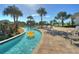 Relaxing lazy river with palm trees and sun loungers by the water for residents to enjoy a sunny day at 4907 Romeo Cir, Kissimmee, FL 34746