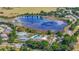 An aerial view showcasing the community's lake, tennis courts, pool, and surrounding homes at 5137 Links Ln, Leesburg, FL 34748