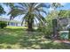 Exterior home view with palm tree and blossoming plants in the backyard at 5137 Links Ln, Leesburg, FL 34748