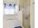 Bathroom showing tub with blue curtains, and glass shower with gold trim at 5137 Links Ln, Leesburg, FL 34748