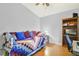 Bedroom with hardwood floors, a daybed, and a bookshelf with a small TV at 5137 Links Ln, Leesburg, FL 34748
