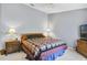 Cozy bedroom with a patterned quilt, neutral walls, and wood furniture at 5137 Links Ln, Leesburg, FL 34748