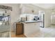 Bright kitchen features white appliances, white tile flooring, and a breakfast bar area at 5137 Links Ln, Leesburg, FL 34748