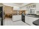 Bright kitchen features white cabinets, tiled floor, black countertops, and black appliances at 5137 Links Ln, Leesburg, FL 34748