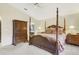 Main bedroom with four-poster bed, carpet flooring, and and nightstands at 5137 Links Ln, Leesburg, FL 34748