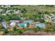 Aerial view showcases community pool and tennis courts surrounded by lush landscaping and trees at 5137 Links Ln, Leesburg, FL 34748
