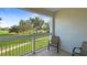 Relaxing balcony with chairs offering a peaceful view of the surrounding golf course and trees at 7683 Heritage Crossing Way # 202, Reunion, FL 34747