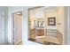 Open doorway from the bathtub to the bathroom with a large mirror and vanity, and open door to another room at 7683 Heritage Crossing Way # 202, Reunion, FL 34747