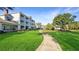 Lush green grass surrounding white buildings with blue balconies at 7683 Heritage Crossing Way # 202, Reunion, FL 34747