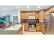 Well-lit kitchen features stainless steel appliances, granite countertops, wood cabinets, and a large sink at 7683 Heritage Crossing Way # 202, Reunion, FL 34747