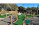Well-maintained miniature golf course with artificial turf and rope fencing in a manicured community space at 7683 Heritage Crossing Way # 202, Reunion, FL 34747