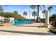 Community pool surrounded by palm trees, lounge chairs, and ample deck space at 7683 Heritage Crossing Way # 202, Reunion, FL 34747