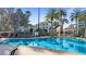 Inviting community pool surrounded by lush palm trees, providing a relaxing resort-style atmosphere at 7683 Heritage Crossing Way # 202, Reunion, FL 34747