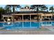 Inviting pool with palm trees and covered seating at 7683 Heritage Crossing Way # 202, Reunion, FL 34747