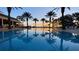 Beautiful pool reflecting palm trees at sunset at 7683 Heritage Crossing Way # 202, Reunion, FL 34747