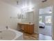 Bright bathroom featuring a soaking tub and a vanity with wooden cabinetry at 7716 Park Hill Ave, Leesburg, FL 34748