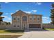 Two-story home with tan stucco exterior, arch window detail, attached two-car garage, and well-manicured lawn at 7716 Park Hill Ave, Leesburg, FL 34748