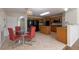 Eat-in kitchen with tiled floors, an island, and plentiful wood cabinetry, adjacent to dining area at 7716 Park Hill Ave, Leesburg, FL 34748
