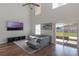 Spacious living room with high ceilings, hardwood floors, large windows, and modern furnishings at 7716 Park Hill Ave, Leesburg, FL 34748