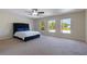 Spacious main bedroom featuring a large bed, neutral carpet, and ample natural light through the large windows at 7716 Park Hill Ave, Leesburg, FL 34748