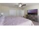 Main bedroom with ensuite entrance, large TV, and closet doors at 7716 Park Hill Ave, Leesburg, FL 34748