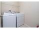 Functional laundry room featuring a white washer and dryer set, accompanied by a wire shelf for storage at 8612 Brookvale Dr, Windermere, FL 34786