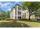 Inviting condo exterior with screened balconies, mature trees, and lush landscaping on a partly cloudy day at 8923 Legacy Ct # 19-102, Kissimmee, FL 34747