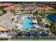 Stunning aerial view of the community pool, clubhouse, and a lake surrounded by homes at 8971 Candy Palm Rd, Kissimmee, FL 34747
