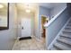 Welcoming foyer with tile floors, featuring a staircase and a view of the downstairs bathroom at 8971 Candy Palm Rd, Kissimmee, FL 34747