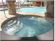 Close up of a bubbling hot tub, offering a relaxing space with a clear view of the community pool at 8971 Candy Palm Rd, Kissimmee, FL 34747