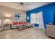 Comfortable living room with tile flooring, a ceiling fan, and a stylish gray sofa at 8971 Candy Palm Rd, Kissimmee, FL 34747