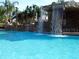 Large pool with rock waterfalls and lush greenery, a perfect oasis at 8971 Candy Palm Rd, Kissimmee, FL 34747