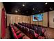 Home theater with plush red seating, a large projection screen, and elegant curtains at 8971 Candy Palm Rd, Kissimmee, FL 34747