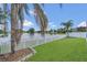 Fenced backyard with a meticulously maintained lawn that overlooks the adjacent lake at 2784 Corbel Loop, Kissimmee, FL 34746