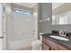 Bathroom featuring a granite vanity, toilet, and a shower-tub combo with white tile at 2784 Corbel Loop, Kissimmee, FL 34746