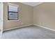 A simple empty bedroom with neutral paint, a window for natural light and grey wood-look flooring at 2784 Corbel Loop, Kissimmee, FL 34746