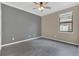 Neutral bedroom featuring grey accent wall, wood-look flooring, and natural light from the window at 2784 Corbel Loop, Kissimmee, FL 34746