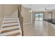 Bright foyer with staircase showcasing tile flooring with backyard views from the sliding doors at 2784 Corbel Loop, Kissimmee, FL 34746