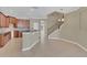 Inviting kitchen area with brown cabinetry, breakfast bar, and decorative staircase at 2784 Corbel Loop, Kissimmee, FL 34746
