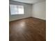 Bright bedroom with wood-look floors, a large window, and white trim at 4745 S Texas Ave # A, Orlando, FL 32839