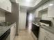 Galley kitchen with white cabinets, laminate counters, range and refrigerator; doorway to adjacent room at 4745 S Texas Ave # A, Orlando, FL 32839