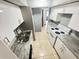 Galley kitchen featuring white cabinets, granite countertops, and white appliances at 4745 S Texas Ave # A, Orlando, FL 32839