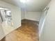 Bright living room with wood-look floors open to the kitchen with white appliances at 4745 S Texas Ave # A, Orlando, FL 32839