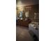 Elegant bathroom with double sinks, wood cabinets, a soaking tub, and updated fixtures at 639 Gull Dr, Poinciana, FL 34759
