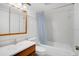 Clean bathroom with wood-trimmed vanity and tub-shower combination featuring tile surround at 1038 Plantation Dr # D9, Kissimmee, FL 34741