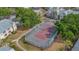 Aerial view showcases a tennis court surrounded by green spaces, mature trees, and buildings at 1051 S Hiawassee Rd # 2127, Orlando, FL 32835