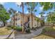 Well-maintained building with yellow siding, black stairs, and mature landscaping at 1051 S Hiawassee Rd # 2127, Orlando, FL 32835