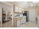 This small kitchen has white cabinets, black appliances, and an adjacent bedroom at 1051 S Hiawassee Rd # 2127, Orlando, FL 32835