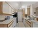 This compact kitchen has white cabinets, white appliances, and tile floors at 1051 S Hiawassee Rd # 2127, Orlando, FL 32835