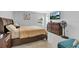 Comfortable bedroom featuring a large bed, dresser with mounted TV, and a cozy blue loveseat at 1083 Snively Cir, Lake Hamilton, FL 33851